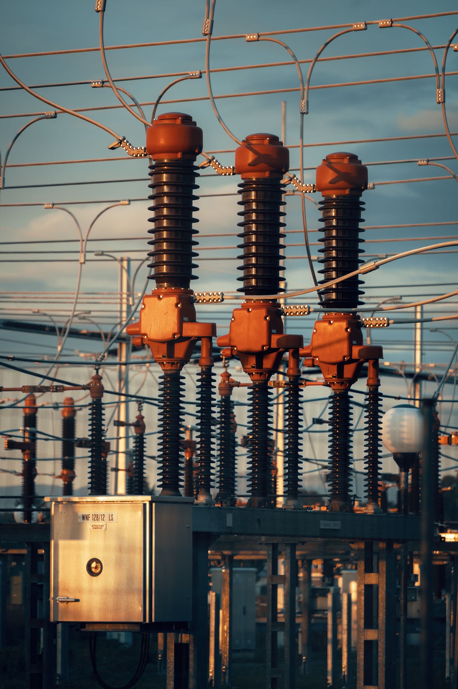 Switching equipment and insulators in a substation yard.